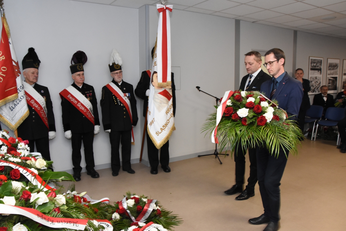 Złożenie kwiat&oacute;w pod tablicą